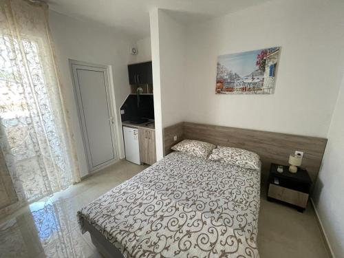 a small bedroom with a bed and a kitchen at Apartments Pericic in Sutomore