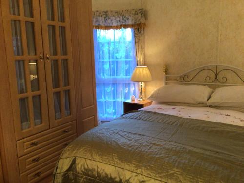 um quarto com uma cama e uma janela em Beautiful 2-Bed holiday home nr Kynance cove em Helston