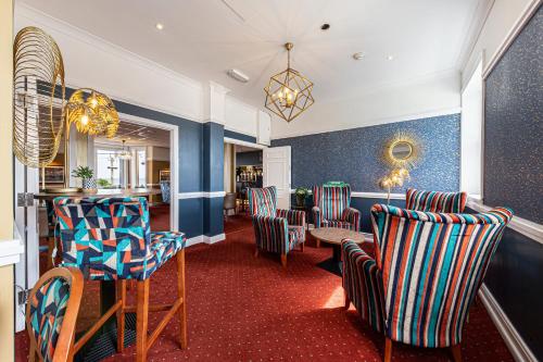 a bar with chairs and a table in a room at The Beaches Hotel and Spa in Prestatyn