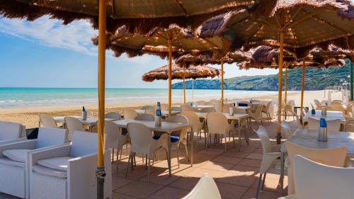 a group of tables and chairs on the beach at Centro Turistico San Nicola in Peschici