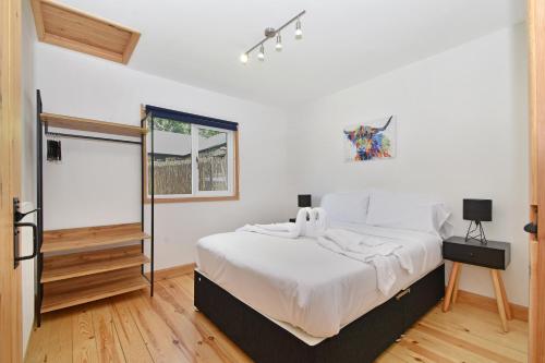 een slaapkamer met een groot bed en een spiegel bij The Cow Shed at Quex Park Estate in Birchington