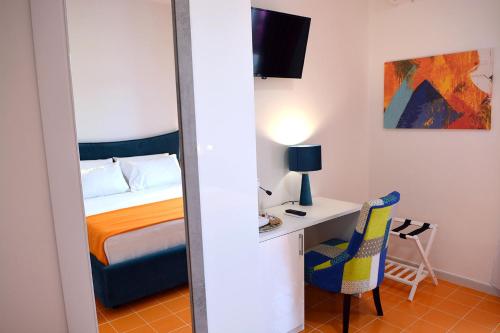 a bedroom with a bed and a desk with a chair at Andrea Room&Breakfast in Capaccio-Paestum