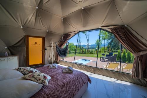 a tent with a bed and a view of a patio at Peak Glamp in Zakopane