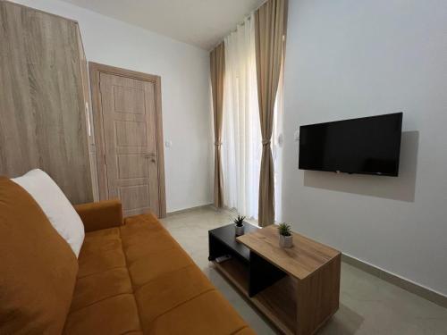 a living room with a couch and a flat screen tv at Apartments Pericic in Sutomore