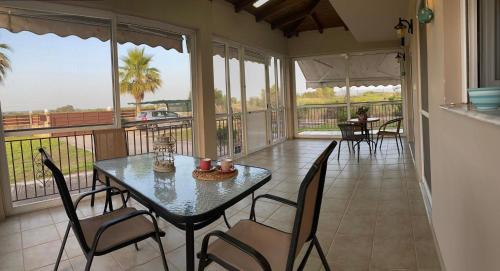 comedor con mesa y sillas en el balcón en Villa Christina ,Kalogria beach, en Metóchion