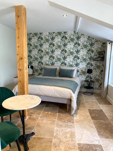 a bedroom with a bed and a table in a room at La Félicité in Boissy-le-Sec