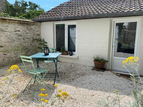 a table and two chairs in front of a house at La Félicité in Boissy-le-Sec