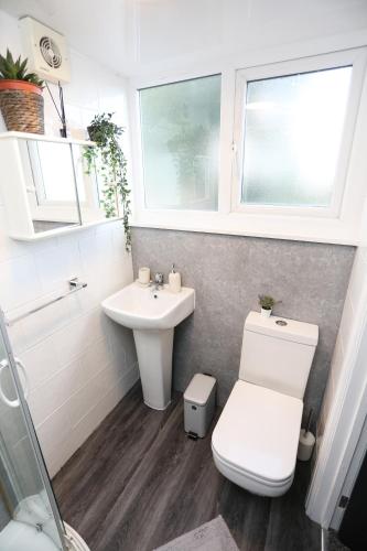 a bathroom with a toilet and a sink at Cheerful 4-bedroom home in Sheffield in Walkley