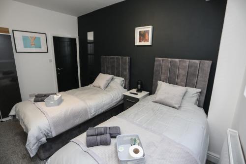 two beds in a room with black walls at Cheerful 4-bedroom home in Sheffield in Walkley