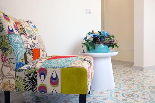a room with a chair and a vase of flowers at Andrea Room&Breakfast in Capaccio-Paestum