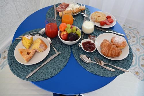 a blue table topped with plates of breakfast foods at Andrea Room&Breakfast in Capaccio-Paestum
