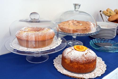 two cakes on plates on a blue table at Andrea Room&Breakfast in Capaccio-Paestum