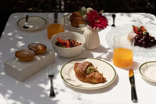 a table with a plate of food and orange juice at Patria Palace Lecce - The Leading Hotels of The World in Lecce