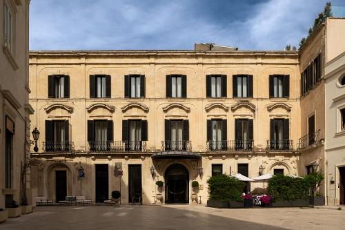 a large building with a balcony in a courtyard at Patria Palace Lecce - The Leading Hotels of The World in Lecce