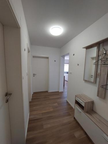 Apartments Marica في كراجسكا غورا: غرفة معيشة فارغة بجدران بيضاء وأرضية خشبية