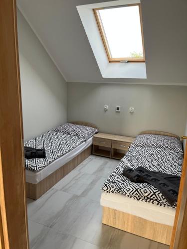 two beds in a room with a window at Wyspówka in Międzyzdroje