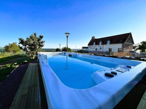 a large swimming pool sitting on top of a house at Le Saltimbanque - Auberge du Moulin in Eaucourt-sur-Somme