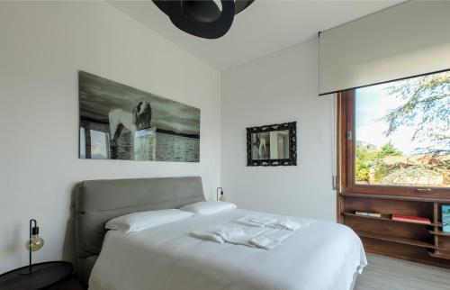 a bedroom with a white bed and a window at Un sogno sul lago Home Relax in Stresa