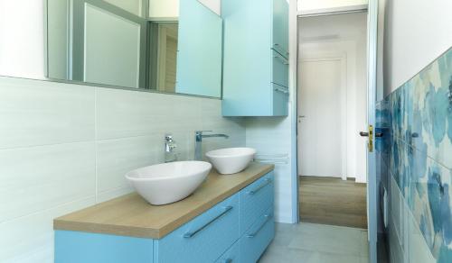 a bathroom with a white sink and a mirror at Un sogno sul lago Home Relax in Stresa