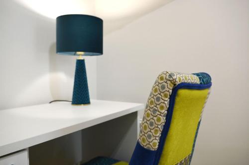 a chair sitting next to a desk with a lamp at Andrea Room&Breakfast in Capaccio-Paestum