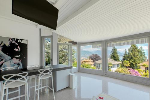 a kitchen with large windows and a counter with stools at Un sogno sul lago Home Relax in Stresa