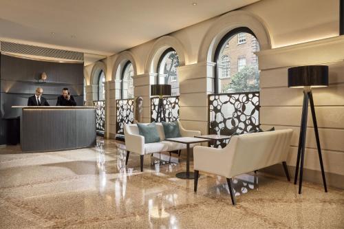 a lobby with two people standing at a counter at COMO The Halkin in London