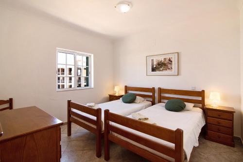 una camera da letto con due letti, un tavolo e una finestra di Apartment Algarve Cabanas de Tavira a Cabanas de Tavira