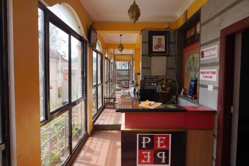a restaurant with a counter and windows at Anika Palace by Pepe Inn Hotel in Ooty