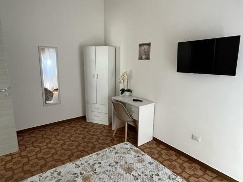 een kamer met een bureau en een tv aan de muur bij Andrea Accomodation in Tropea