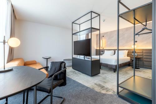 a hotel room with a bed and a table at Novotel Liverpool Paddington Village in Liverpool