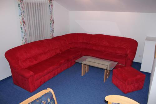 a red couch and a table in a room at Untersteinhof in Forstau