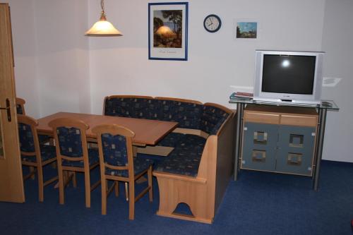 a room with a table and chairs and a television at Untersteinhof in Forstau