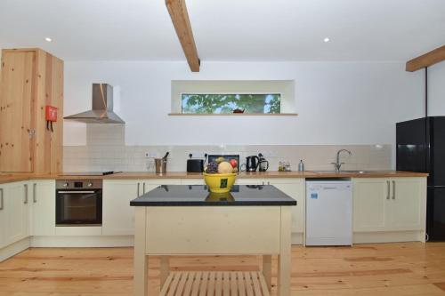 a kitchen with a island with a yellow bowl on it at 5 Bed Barn Conversion - with private hot tub in Birchington