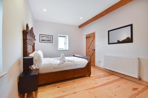 a bedroom with a bed in a room with white walls at 5 Bed Barn Conversion - with private hot tub in Birchington