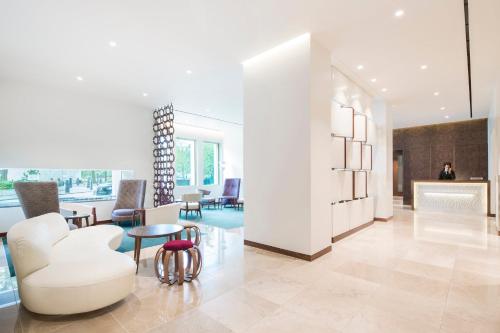 a lobby with a white chair and a table at COMO Metropolitan London in London