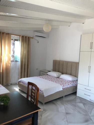 a bedroom with a bed and a desk and a table at Vila Eriseld in Ksamil