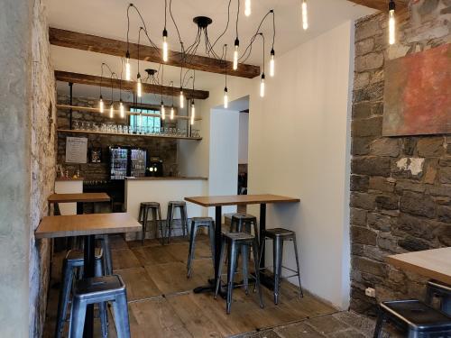 une rangée de tables dans un bar avec tabourets dans l'établissement Hotel Le Moulin Des Ramiers, à Crupet