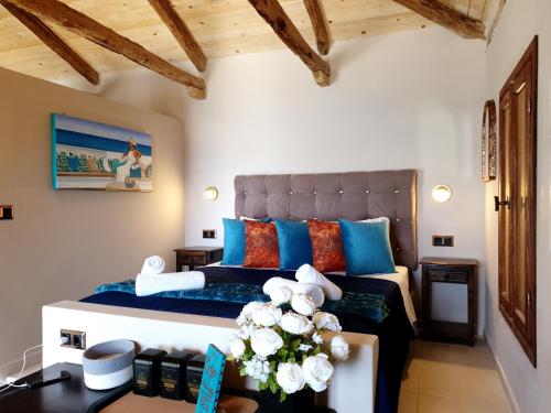 Schlafzimmer mit einem Bett mit blauen und orangefarbenen Kissen in der Unterkunft Reithron House in Frikes