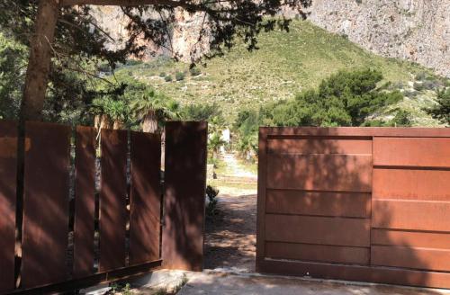 a wooden gate with a mountain in the background at Araja Villa&Suite by Geocharme in San Vito lo Capo