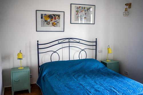 a bedroom with a blue bed with two night stands at Vicolo delle Forbici in Città della Pieve