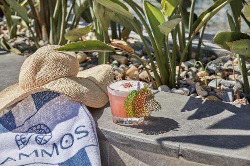 a drink sitting on a bench with a hat at Rammos Managed By Dedeman in Bodrum City
