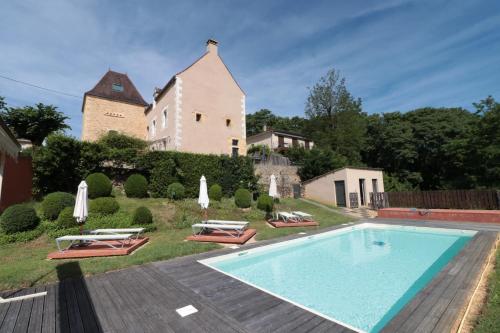une villa avec piscine devant une maison dans l'établissement la maison du moulin a vent, à Sarlat-la-Canéda