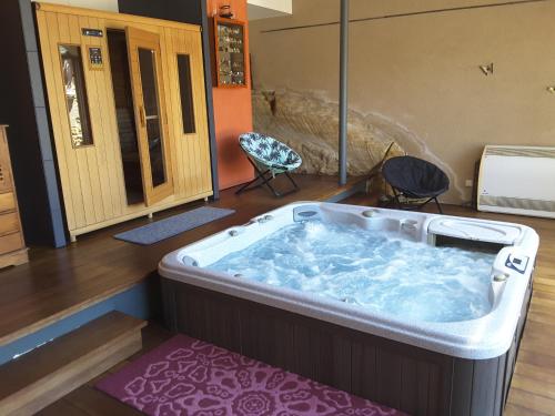 - un grand bain à remous dans une pièce avec 2 chaises dans l'établissement la maison du moulin a vent, à Sarlat-la-Canéda