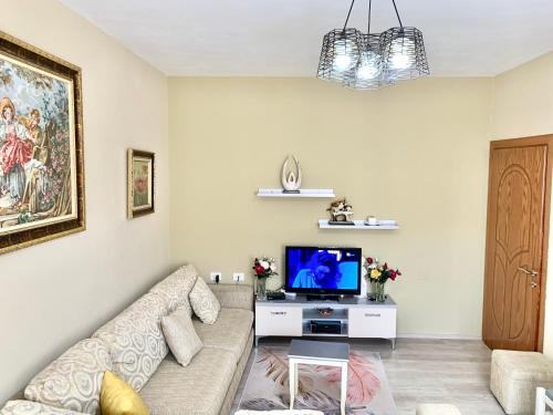 ein Wohnzimmer mit einem Sofa und einem TV in der Unterkunft Syzo Apartments in Pogradec