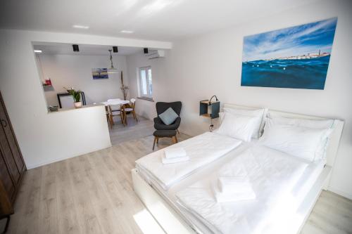 1 dormitorio con cama blanca y mesa en Aloha apartments, en Koper