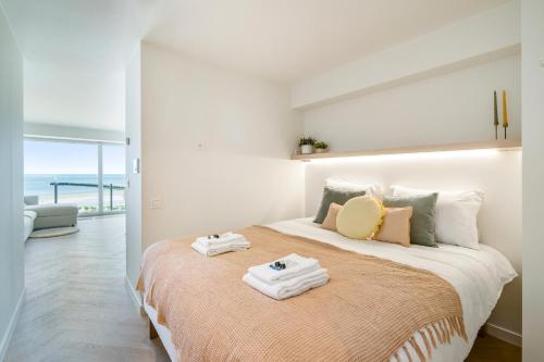 a bedroom with a large bed with towels on it at Moderne studio met fantastisch frontaal zeezicht in Nieuwpoort