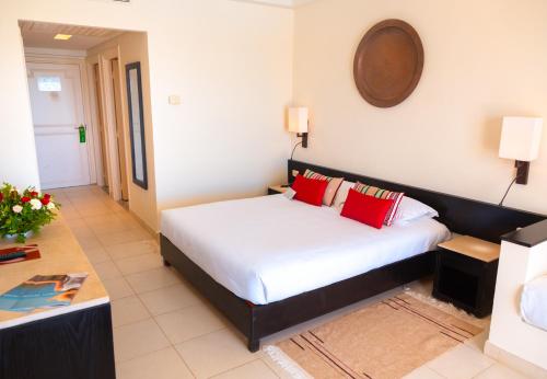 a bedroom with a bed with red pillows at Vincci Dar Midoun in Djerba