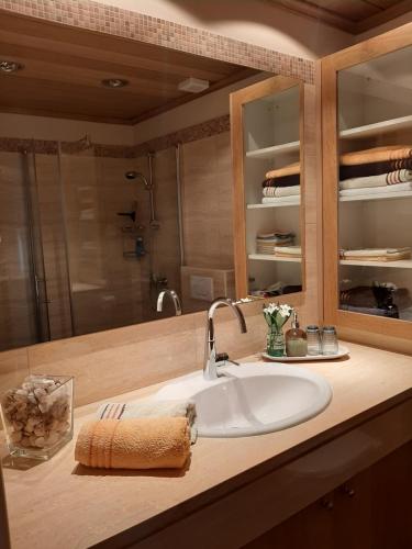 a bathroom counter with a sink and a mirror at Limnaria Deluxe Maisonette in Nea Paphos