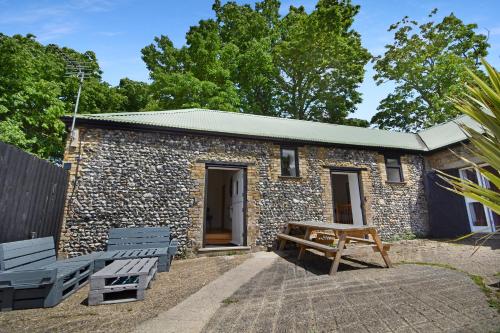 a stone building with two benches and a picnic table at 5 Bed Barn Conversion - with private hot tub in Birchington