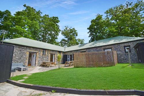 a stone house with a garden in front of it at 5 Bed Barn Conversion - with private hot tub in Birchington